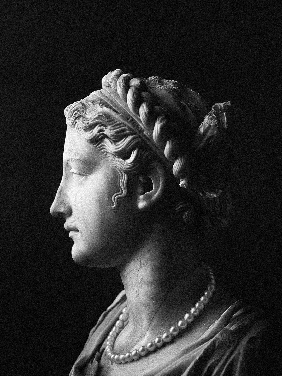 Marble statue of Sappho on side profile.